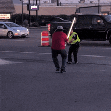 a man in a red shirt is holding a light saber in front of a sign that says metro