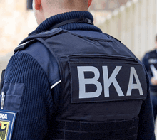 a man wearing a black vest with the word bka on it