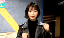a woman wearing a black leather jacket is standing in front of a sign that says cubs