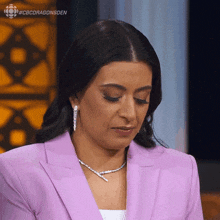 a woman wearing a purple jacket and a diamond necklace is on a cbs dragonsden show