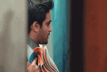 a man in a suit is holding a stack of towels in his hands .