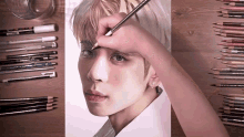 a person is drawing a man 's face with a pencil and a stack of colored pencils