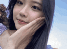 a close up of a girl 's face with her hand on her chin