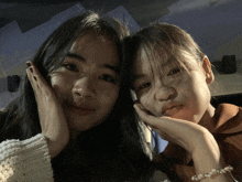 two girls are posing for a picture and one has a pearl bracelet on her wrist