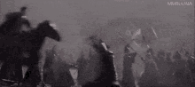 a group of people are fighting each other in a dark room with swords .