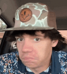 a man wearing a hat with a smiley face on it is making a funny face