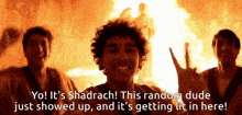 a group of young men are standing in front of a fire with the caption " yo ! it 's shadrach ! "