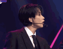 a man in a suit and tie with a microphone in his ears