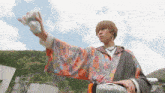 a man in a colorful kimono is holding something in his hands