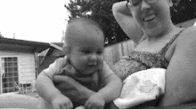 a woman is holding a baby in her arms and the baby is crying .