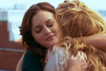 two women hugging each other with one wearing a ring on her finger