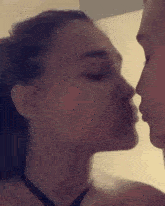 a man and a woman are kissing in a room .