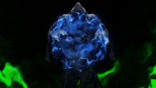 a person is standing in front of a blue sphere in the dark .