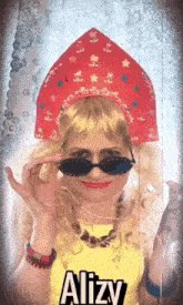 a woman wearing a red hat and sunglasses has the name alizy written on her shirt