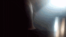 a person 's legs are visible in a blurry photo with a light behind them .