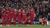 a group of soccer players kneeling on the field in front of a crowd with canal + in the background