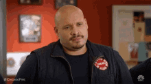 a bald man with a beard and mustache is wearing a chicago firefighter jacket .