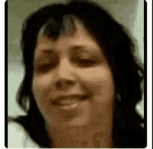 a close up of a woman 's face with a blurry background and a smile on her face .