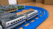 a toy train is going down a track with other trains