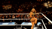 a woman in a wrestling ring with a sign that says ' smack down '