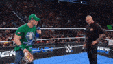 a man in a green shirt that says ' john cena ' on it is talking into a microphone