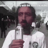 a man with a beard is holding a bottle of water in front of his mouth .