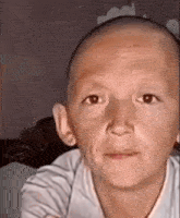 a close up of a child 's face with a bald head .