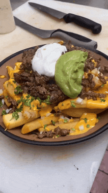 a close up of a plate of food with guacamole and sour cream