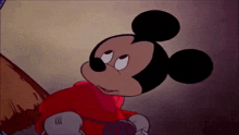 mickey mouse is wearing a red jacket and gloves and looking at something .