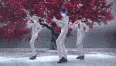 a group of anime characters dancing in front of a tree with red leaves