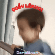 a blurry picture of a child holding a cell phone with the word quay len written on his head