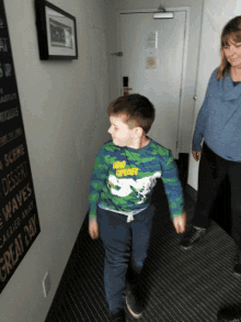 a boy walking down a hallway with a sign that says great day