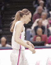 a female basketball player wearing a white jersey with the number l on it
