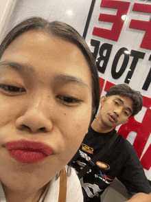 a man and a woman are posing for a picture in front of a sign that says ' lobe '