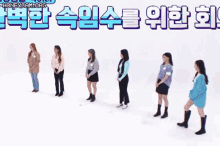 a group of women are standing in a line on a snowy surface .