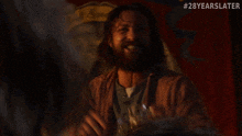 a man with a beard is screaming in front of a sign that says god