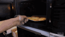 a person is putting a slice of pizza into a microwave oven that is made in animatica