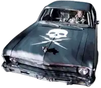 a man is driving a car with a skull on the hood