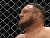 a man with a beard is standing in a cage