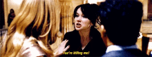 a woman is talking to a man and another woman and says you 're killing me .