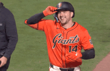 a man wearing an orange san diego jersey laughs on the field