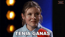 a woman is holding a microphone and says " tenia ganas " in spanish