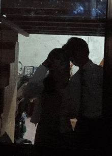 a man and a woman are standing in a dark room