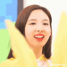 a close up of a woman 's face with her mouth open and a yellow shirt on .