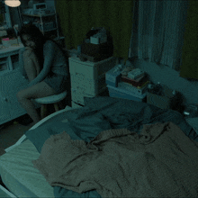 a woman is sitting on a toilet in front of a dresser