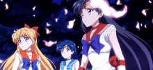 a group of three anime girls are standing next to each other in a dark room .
