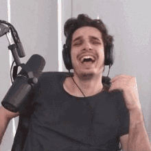a man wearing headphones and a microphone is sitting in front of a microphone .