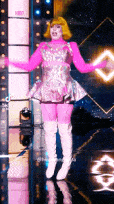 a woman in a pink dress and white boots is on a stage .