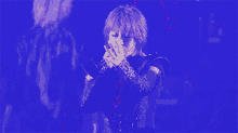 a woman is singing into a microphone in a dark room