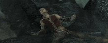 a person is laying on a rock in a dark cave